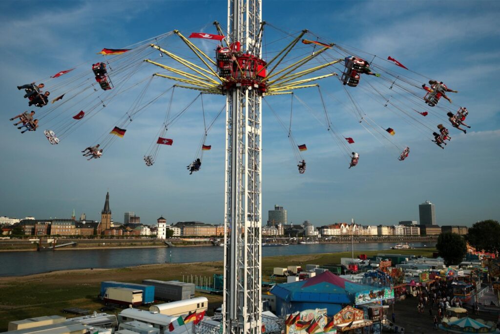 Kirmesbesucher auf der Rheinkirmes in Düsseldorf in einem Kettenkarussell. Kirmesbesucher auf der Rheinkirmes in Düsseldorf in einem Kettenkarussell.