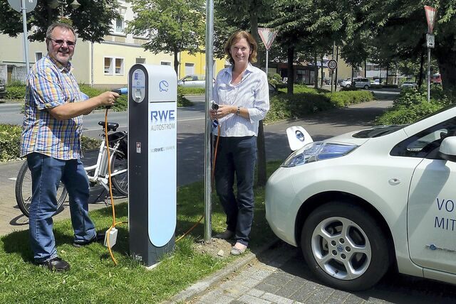 Ein Mann und eine Frau stehen vor einer Strom-Tankstelle in Oer-Erkenschwick