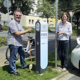 Ein Mann und eine Frau stehen vor einer Strom-Tankstelle in Oer-Erkenschwick