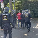 Polizisten führen einen gewalttätigen Fußballfan in einem Trikot von Cristiano Ronaldo ab. Hierbei handelt sich nur um eine Übung für die Fußball-Europameisterschaft 2024.