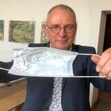 Johannes Gröger zeigt einen Spickzettel in einer Corona-Maske