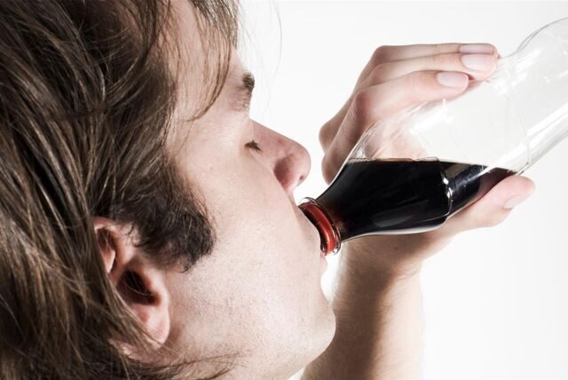 Ein junger Mann trinkt eine Cola. (Symbolbild)