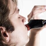 Ein junger Mann trinkt eine Cola. (Symbolbild)