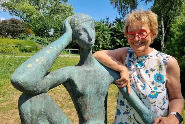 Eine Frau steht an einer Skulptur