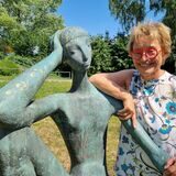 Eine Frau steht an einer Skulptur