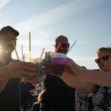 Vier Menschen stoßen während der Veranstaltung „Waltrop Karbisch“ mit ihren Getränkebechern an.