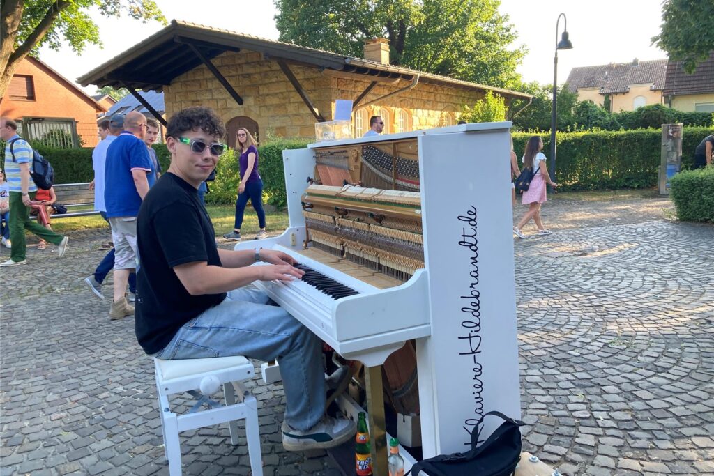 Ein junger Mann spielt auf einer Kopfsteinpflasterfläche am Schiffshebewerk Henrichenburg in Waltrop Klavier. Im Hintergrund sind einige Besucher der Veranstaltung Extraschicht zu erkennen. Ein junger Mann spielt auf einer Kopfsteinpflasterfläche am Schiffshebewerk Henrichenburg in Waltrop Klavier. Im Hintergrund sind einige Besucher der Veranstaltung Extraschicht zu erkennen.