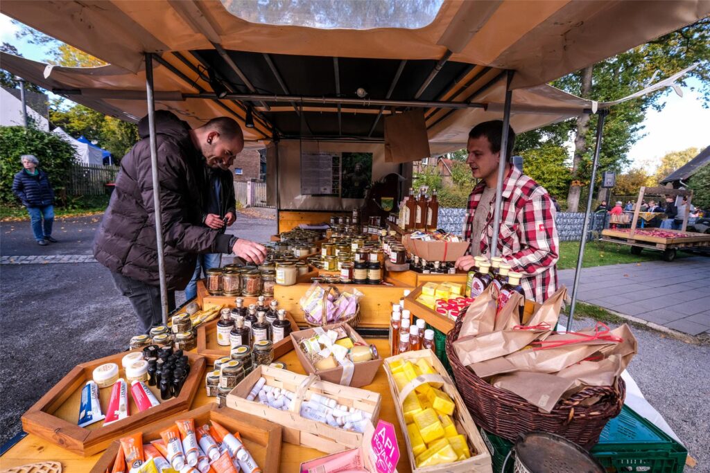 Ein Mann verkauft auf dem Bauernmarkt in Hochlar seine Waren an einem Stand. Ein Mann verkauft auf dem Bauernmarkt in Hochlar seine Waren an einem Stand.