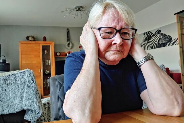 Eine Frau hält sich die Ohren wegen des sie umgebenden Lärms zu.