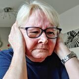 Eine Frau hält sich die Ohren wegen des sie umgebenden Lärms zu.