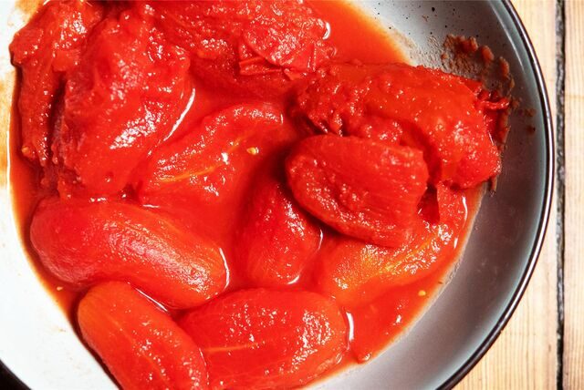 Geschälte Tomaten aus der Dose liegen auf einem Teller