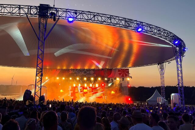 Das Sunset Beach Festival in buntes Scheinwerferlicht getaucht.