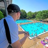 Ein Mitarbeiter des Bades schaut von einem Aussichtspunkt auf die Badegäste im Freibad Mollbeck in Recklinghausen.