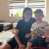 Esliona Cangollari (32) und ihr Sohn Noel Goxhaj (3) sitzen im Wohnzimmer, die Mutter auf einem Teppich, der Dreijährige auf einem Spielauto.
