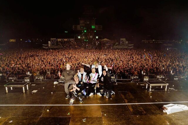 Die Band Electric Callboy steht auf der Bühne des Ferropolis-Festivals, tausende Fans jubeln im Hintergrund.