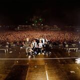 Die Band Electric Callboy steht auf der Bühne des Ferropolis-Festivals, tausende Fans jubeln im Hintergrund.