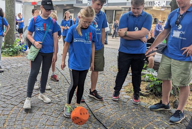 Ein Mädchen würfelt mit einem großen Würfel. Die Aufgabe war Teil des Stadtspiels der Sportplatz-Olympiade am Donnerstag.