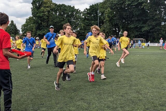 Kinder rennen zur Siegerehrung der Sportplatz-Olympiade.