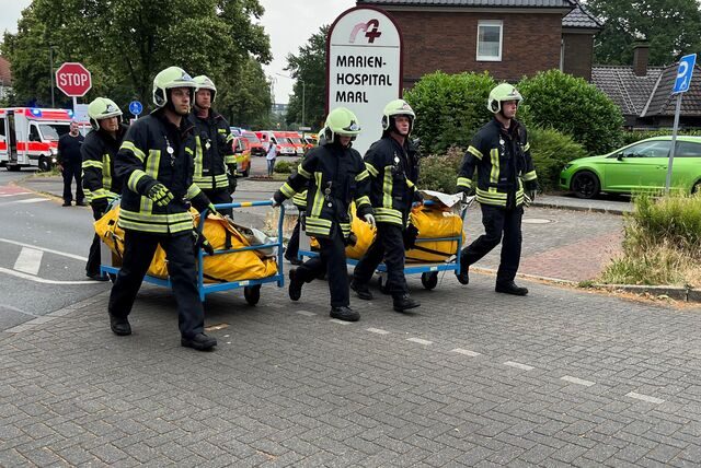 Feuerwehrleute kommen mit Ausrüstung an.