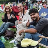 Navid (rechts) ist mit vielen Freunden zum DJ Picknick in den Fredenbaumpark gekommen. Die Gruppe macht es sich auf Liegestühlen bequem.