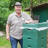 Mann vor Bienenkasten