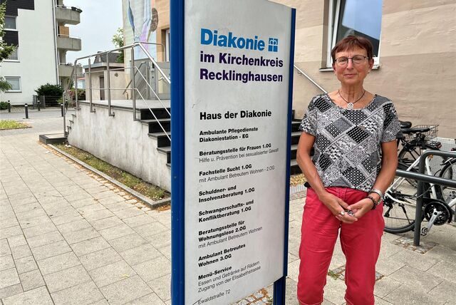 Susanne Rohn vor dem Haus der Diakonie neben einem Schild.
