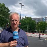 Montage: RN-Reporter Oliver Volmerich mit einem Mikrofon vor dem Dortmunder U und der Baustelle
