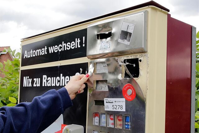 Praktikantin Tabea Artmannselm am demolierten Zigarettenautomaten an der Straße Im Hohen Winkel