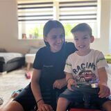 Esliona Cangollari (32) und ihr Sohn Noel Goxhaj (3) sitzen im Wohnzimmer, die Mutter auf einem Teppich, der Dreijährige auf einem Spielauto.