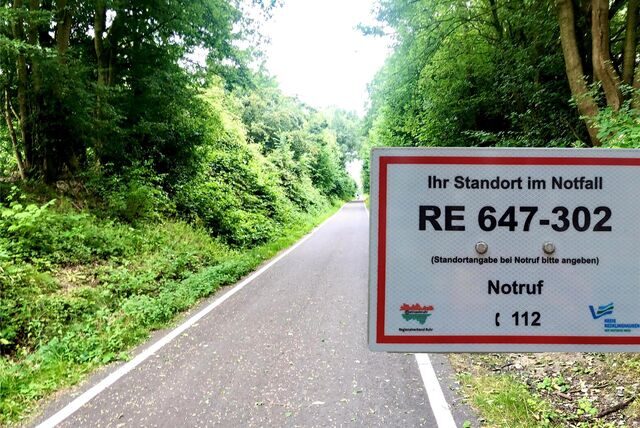Schild eines Rettungspunkts vor einer Trasse