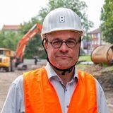 Ein Mann mit Helm steht auf einer Baustelle.
