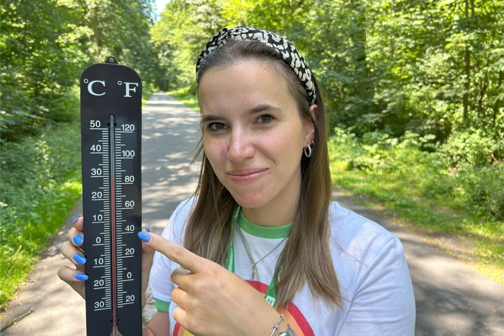 RZ-Redakteurin Janine Jähnichen zeigt im Hohenhorster Wald in Recklinghausen auf ein Thermometer, das die 30 Grad-Grenze erreicht hat