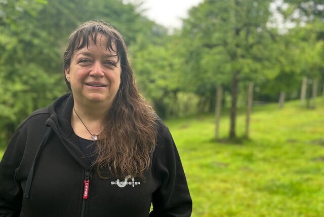 Streuobst-Pädagogin Michaela Scheideler steht auf einer Streuobstwiese.