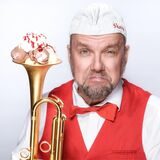 Ein Mann im Kostüm eines Eisverkäufers hält eine Trompete, darin Speiseeis.