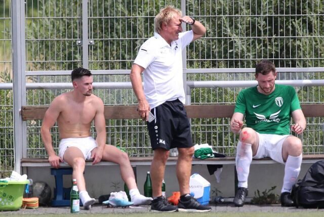 Markus Droste (rechts im Bild), stellvertretender Geschäftsführer beim FC/JS Hillerheide, half Trainer Markus van Dunderen (mittig im Bild) bei der Stadtmeisterschaft aus. Die Beiden sitzen auf der Bank, van Dunderen schützt seine Augen vor der Sonne. Maurice Dietsch lüftet sein Trikot links.