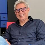 Frank Stötzer hat sich auf einen Stuhl des Designers Gerrit T. Rietveld gesetzt. Der wurde vor zirka 100 Jahren entworfen. Das Modell ist ein Nachbau aus den 1980er Jahren. Im Hintergrund ist ein Barschrank zu sehen.