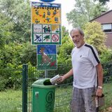 Ein Mann leert eine Dose in einen Mülleimer.