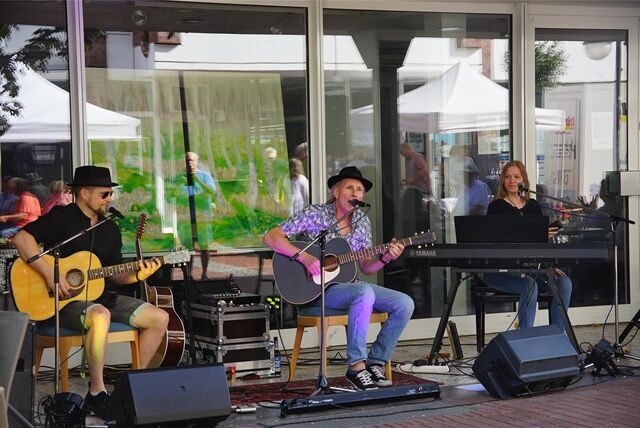 Das Trio Two Gents spielt ein Konzert vor einer Schaufenster-Front in Waltrop.