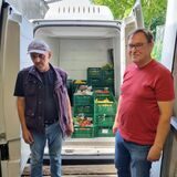 Zwei Männer stehen vor einem Ford Transit.