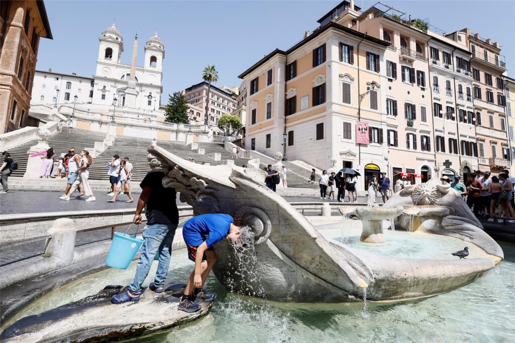 Eine Junge kühlt sich in der Fontana della Barcaccia vor der Spanischen Treppe in Rom ab Eine Junge kühlt sich in der Fontana della Barcaccia vor der Spanischen Treppe in Rom ab