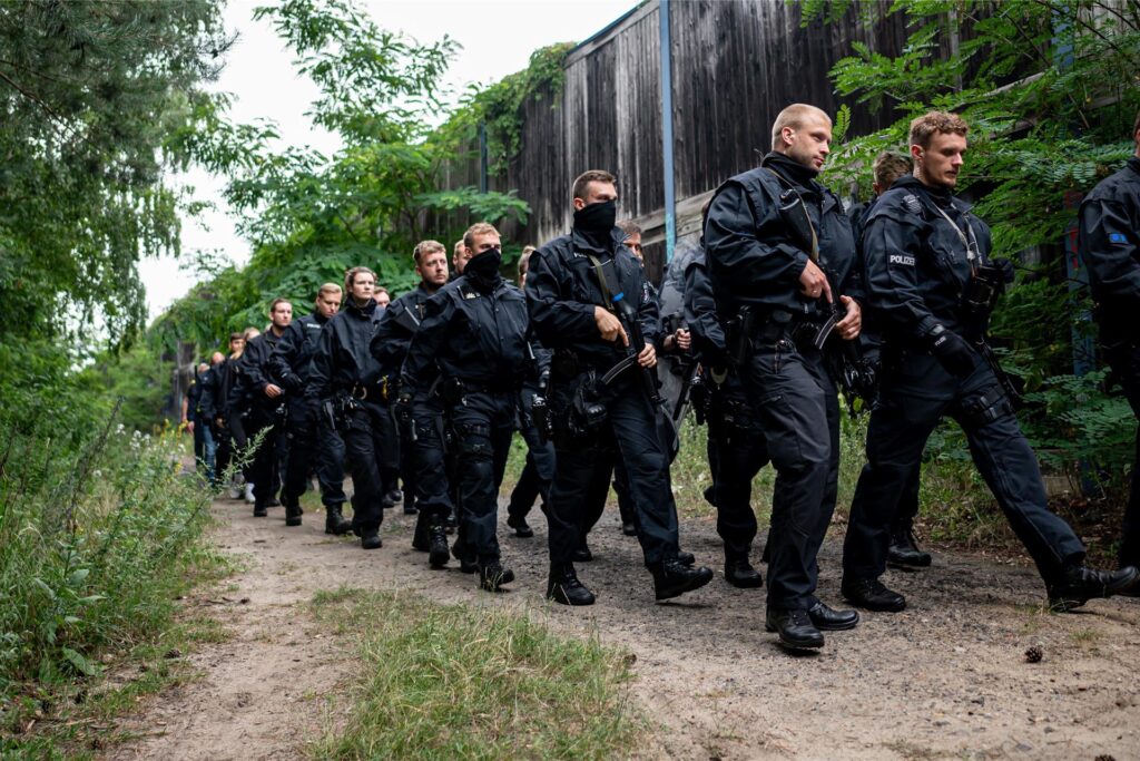 Polizisten laufen im Bereich der südlichen Landesgrenze von Berlin. Polizisten laufen im Bereich der südlichen Landesgrenze von Berlin.