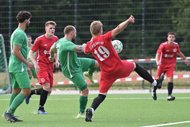 Ein Fußballspieler des FC Spvgg. Oberwiese (rote Trikots) versucht einen Schuss abzublocken.