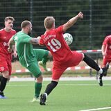 Ein Fußballspieler des FC Spvgg. Oberwiese (rote Trikots) versucht einen Schuss abzublocken.