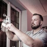 Spirituosen-Experte Sebastian Büssing füllt aus einer Flasche eine klare Flüssigkeit in ein Glas.