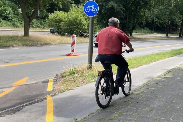 Ein Mann  fährt auf einem Fahrradweg.