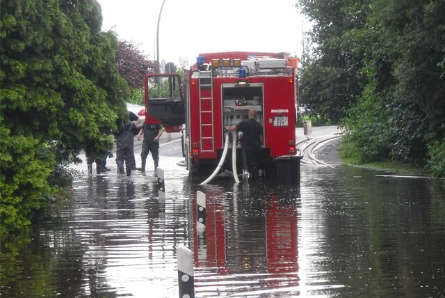 Feuerwehrwagen steht auf einer überfluteten Straße