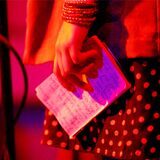 Eine Autorin hält bei einem Poetry Slam ihre Notizen in der Hand