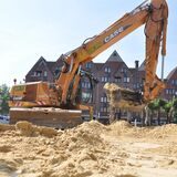 Ein Bagger schippt Sand auf den Castroper Marktplatz in der Altstadt