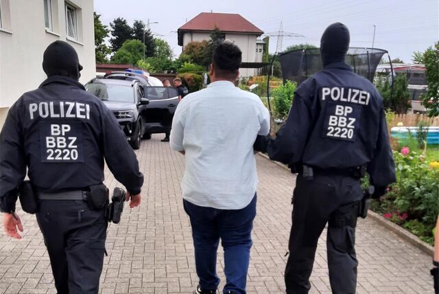 Polizisten nehmen einen Beschuldigten in Landau in der Pfalz fest.
