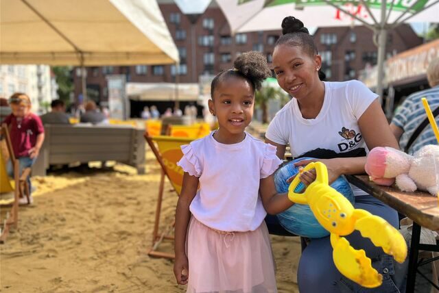 Gleny Mejia und ihre Tochter Yoleiny Moya (3) spielen zusammen im Sand.